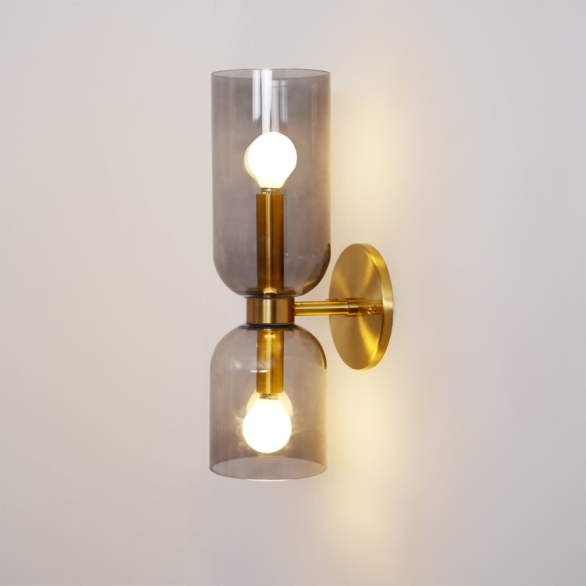 From an angle, the smoke grey shades on this gold Clérachic wall light glow warmly.