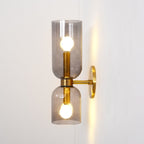 A faint wire trace runs beside this gold Clérachic sconce, its smoke grey shades lit.