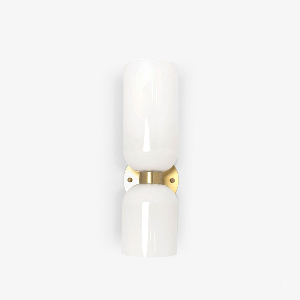 A close crop of this gold Clérachic sconce's glossy opal shade against a cream backdrop.