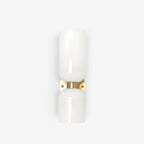 A close crop of this gold Clérachic sconce's glossy opal shade against a cream backdrop.