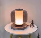 A wider view of the Clérachic table lamp on its round table, the yellow stand legs and toy bicycle visible in frame.
