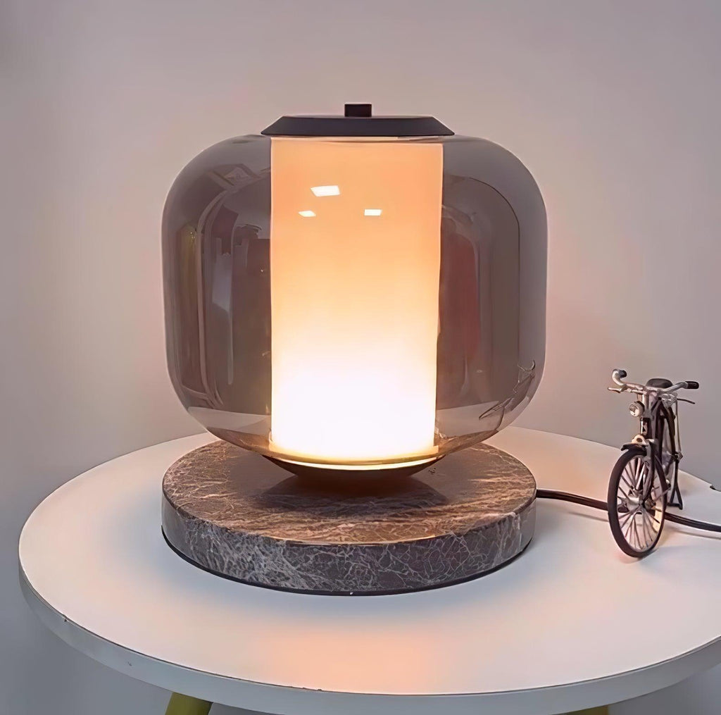 The lit Clérachic table lamp on its round table, the toy bicycle and yellow stand legs both visible in this wider shot.
