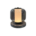 A small full product shot of the Clérachic table lamp glowing warm amber, isolated against a plain grey background.
