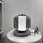 The same Clérachic table lamp on the bedside table now glows cool white rather than warm amber, showing the light tone option.