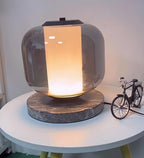Close-up of the Clérachic table lamp's glass dome with the toy bicycle prop just visible at the edge of frame.