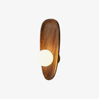 Walnut wood wall lamp mounted on a plain wall, lit