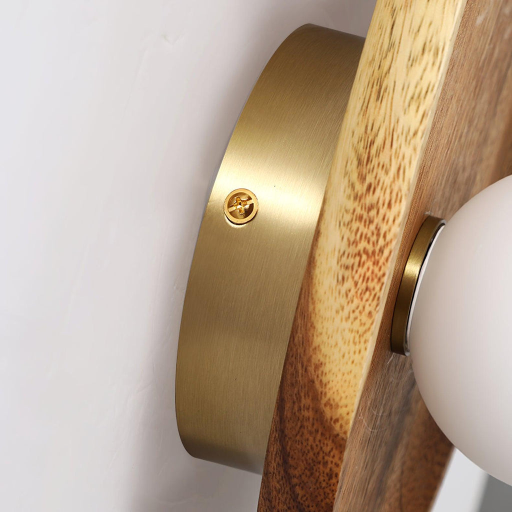 Walnut wood wall lamp shown lit against a neutral backdrop