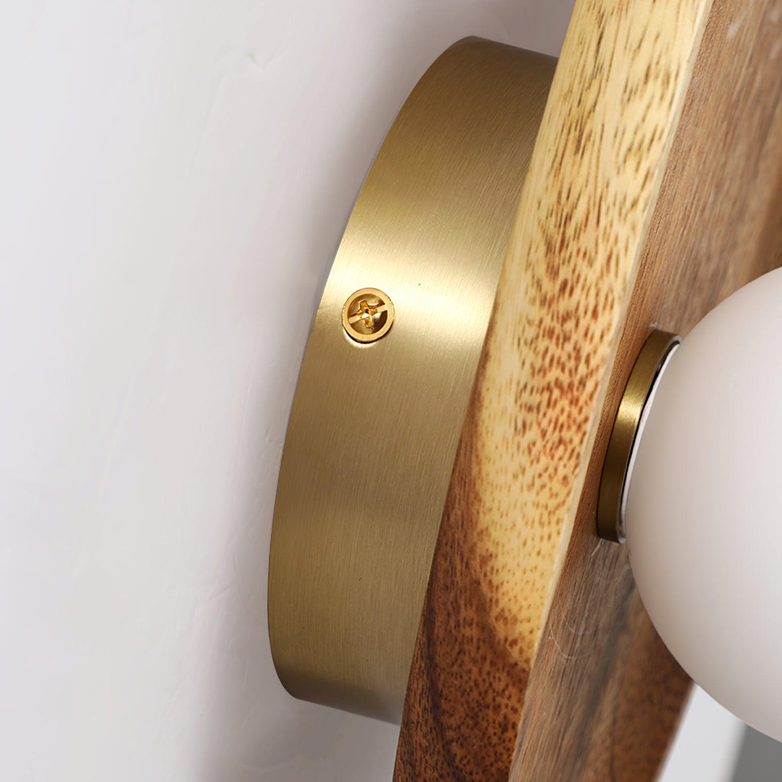 Walnut wood wall lamp shown lit against a neutral backdrop