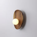 Walnut wood wall lamp casting a soft ambient glow on an accent wall