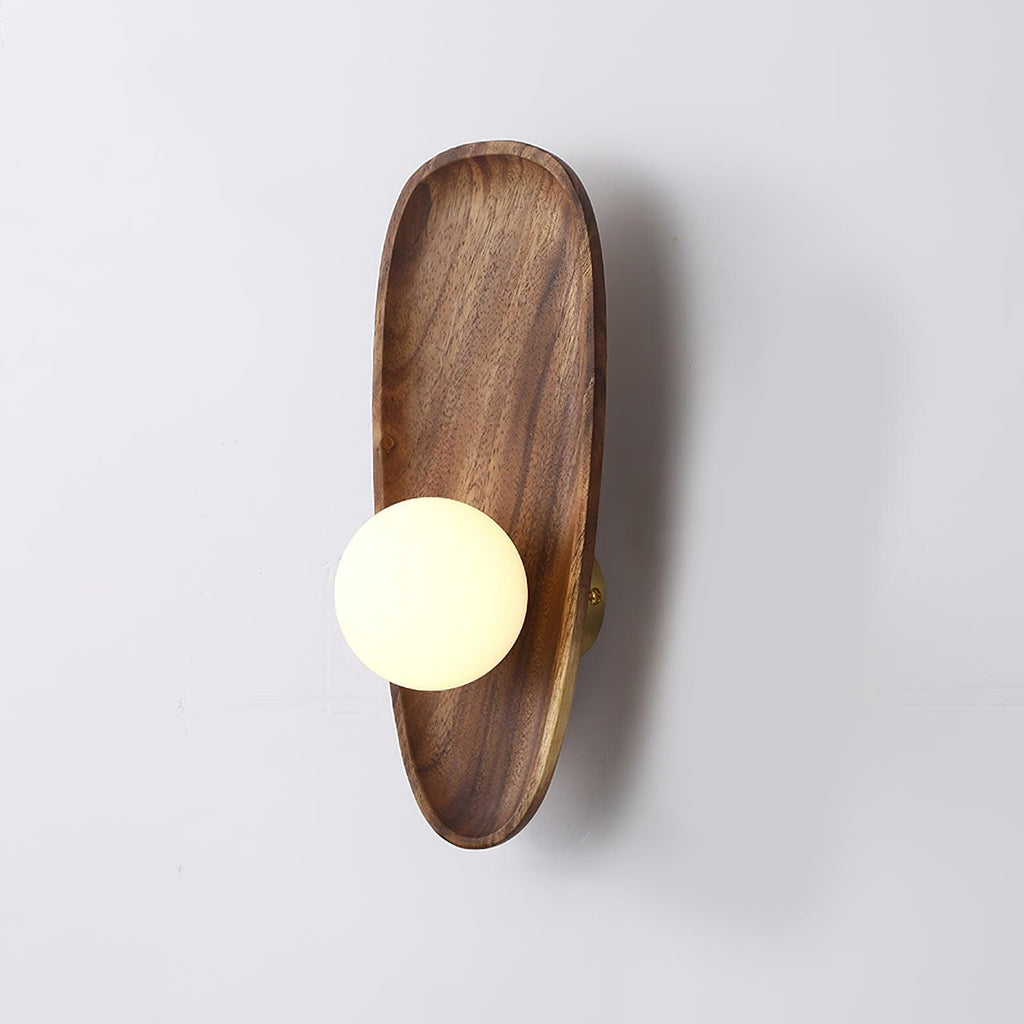 Walnut wood wall lamp shown lit in a warm minimal interior