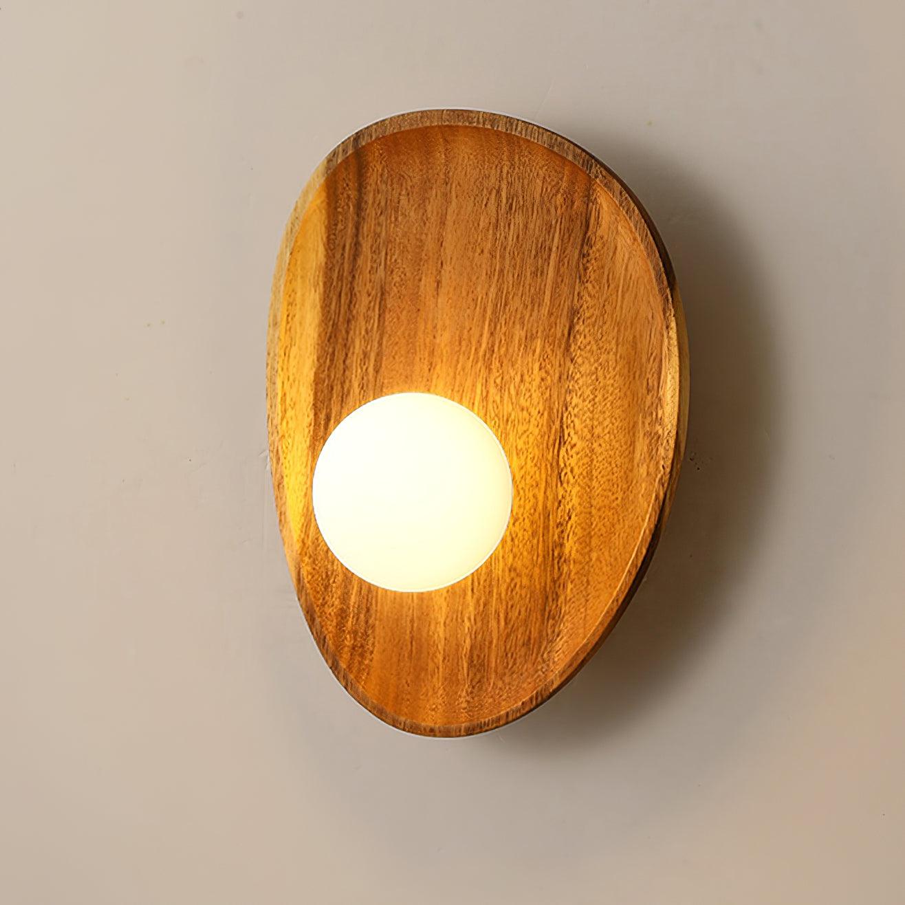 Walnut wood wall lamp glowing on an accent wall