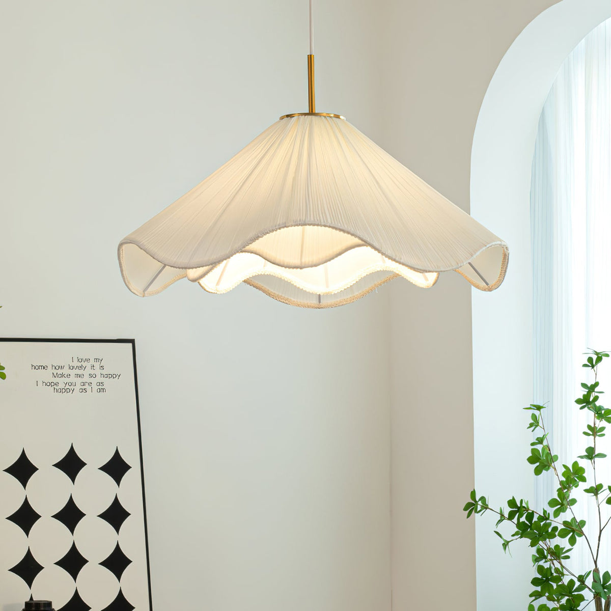 Beside a black-and-white patterned print, this beige Clérachic pendant light hangs near a trailing green plant.
