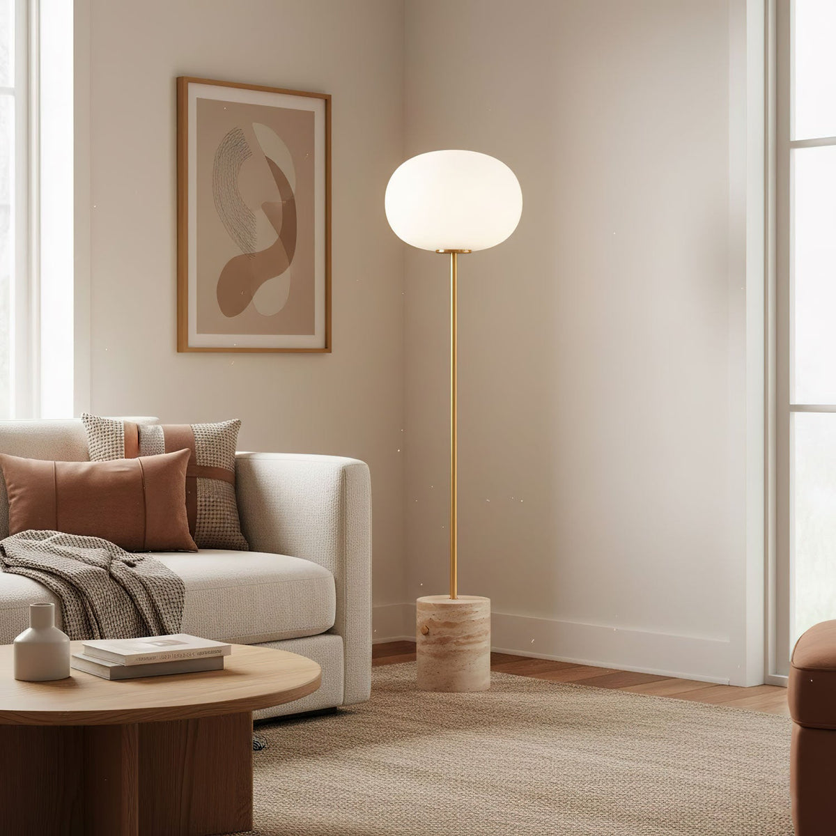 The Clérachic floor lamp lights a minimal corner beside a beige sofa with terracotta and rust-toned cushions.