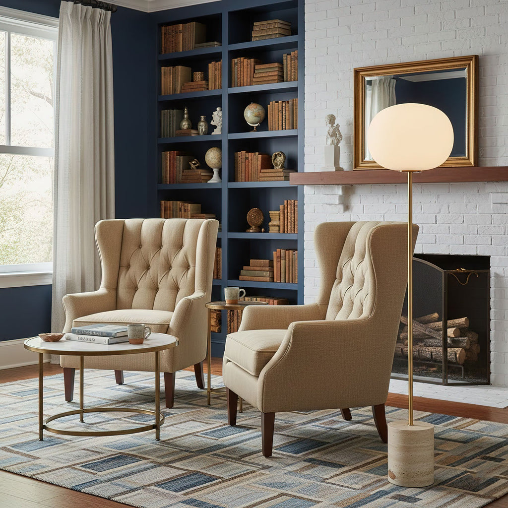 A navy-walled reading nook shows the Clérachic floor lamp between two tufted wingback chairs and built-in bookshelves.