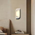 Short Elaris Alabaster Wall Light in black above a bedroom nightstand, next to a boucle upholstered bed.