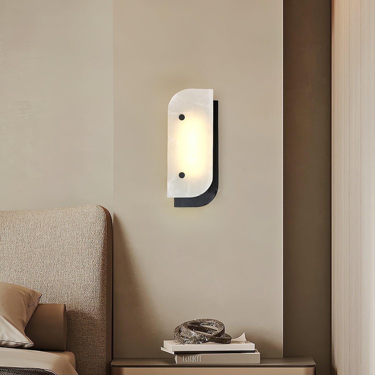 Short Elaris Alabaster Wall Light in black above a bedroom nightstand, next to a boucle upholstered bed.
