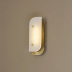 Short Elaris Alabaster Wall Light mounted on a warm taupe wall, brass backplate catching the lamp's own glow.