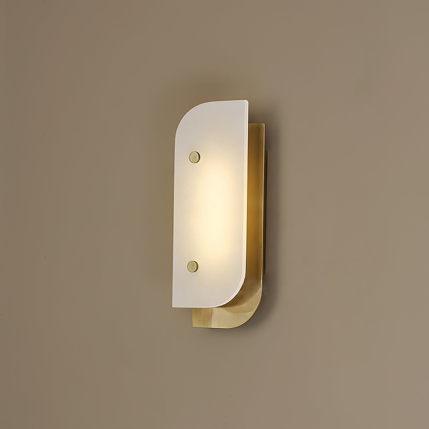 Short Elaris Alabaster Wall Light mounted on a warm taupe wall, brass backplate catching the lamp's own glow.