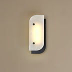 Short Elaris Alabaster Wall Light in black on a taupe wall, stone veining visible in the warm light.