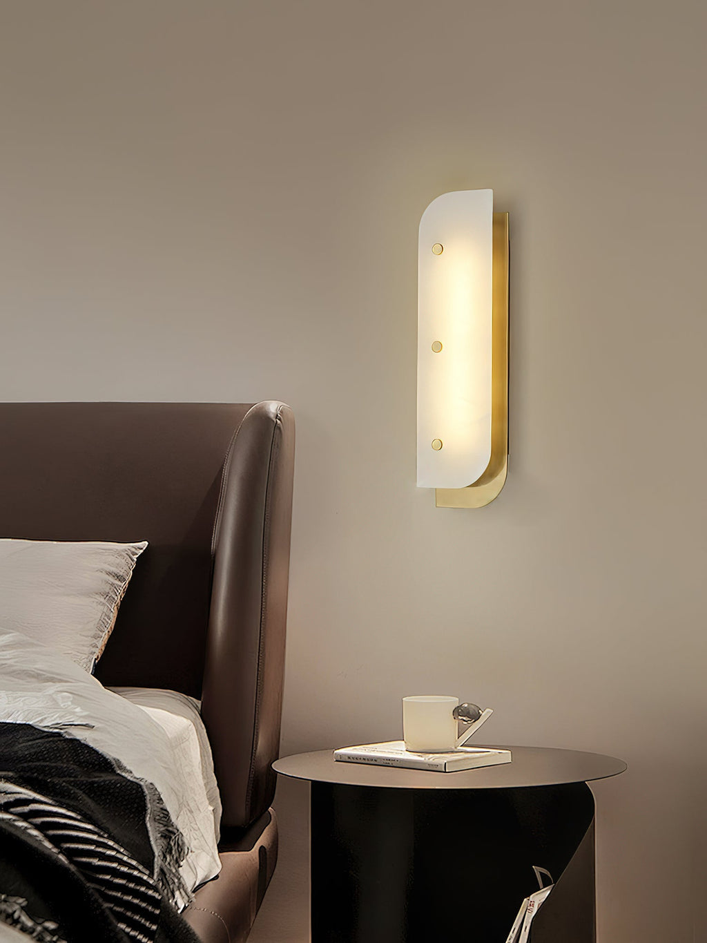 Tall Elaris Alabaster Wall Light in brass at the bedside, warm pool of light over the nightstand.