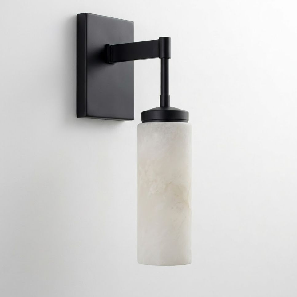 In matte black, this Clérachic wall sconce stands alone on a plain white backdrop, its arm bent at a right angle.