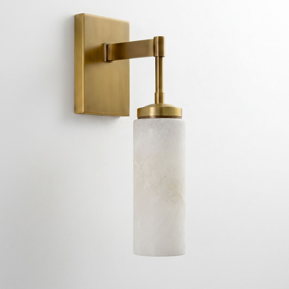 Another angle in brushed brass shows this Clérachic sconce's flat cap and cylindrical alabaster shade in full.