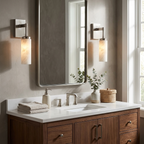 Two dark-finished Clérachic sconces frame a mirror above a walnut vanity with brass tap hardware.