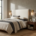 A small brass pair of these Clérachic sconces flanks an upholstered headboard beside a walnut nightstand.