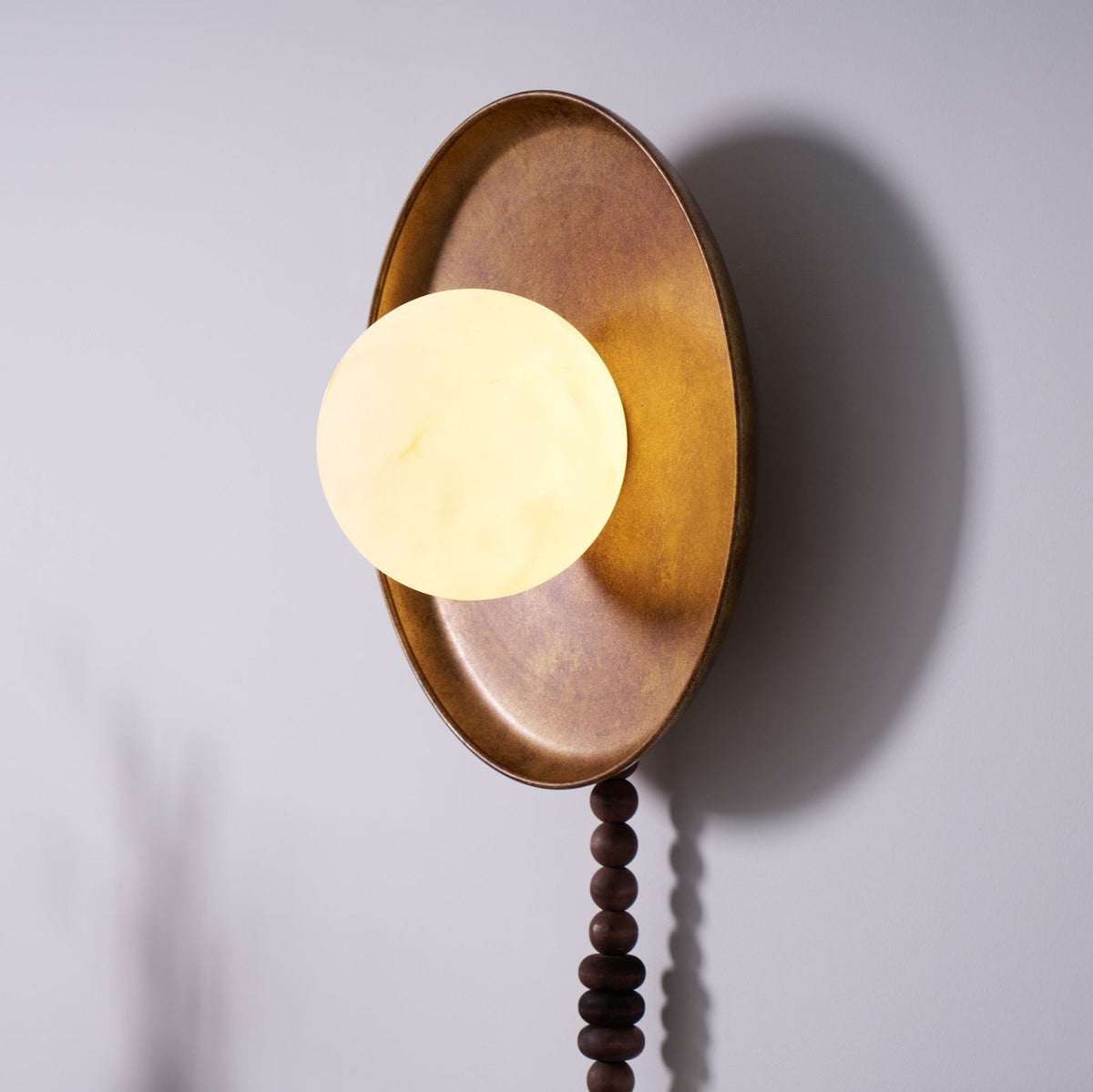 Cropped tighter on white, this angled view shows only the Clérachic sconce's shade and tray, beads out of frame.