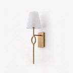Front view on a plain backdrop, the brushed brass finish of this Clérachic wall sconce highlights its slender rod and oval ring.
