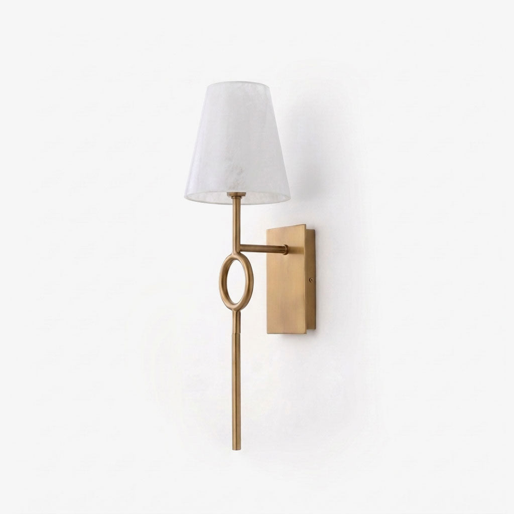 Front view on a plain backdrop, the brushed brass finish of this Clérachic wall sconce highlights its slender rod and oval ring.