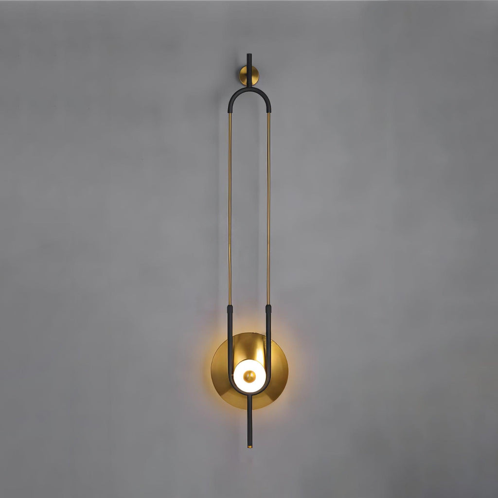 A closer crop of the same Clérachic wall sconce on a grey wall, filling the frame from its gold hook to the round light.