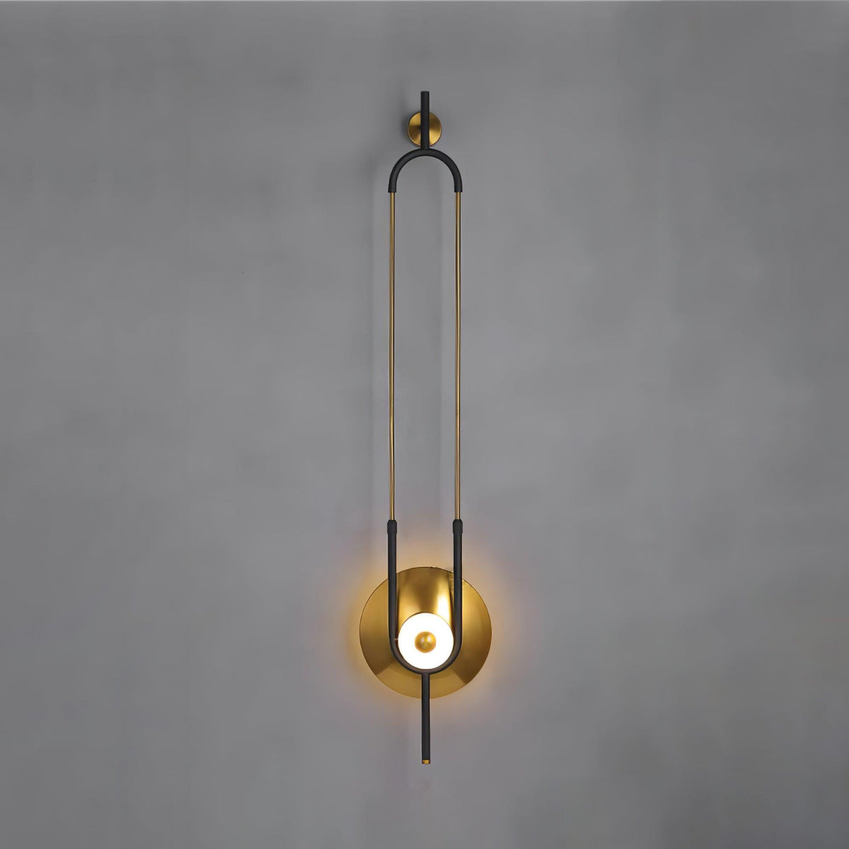 A closer crop of the same Clérachic wall sconce on a grey wall, filling the frame from its gold hook to the round light.