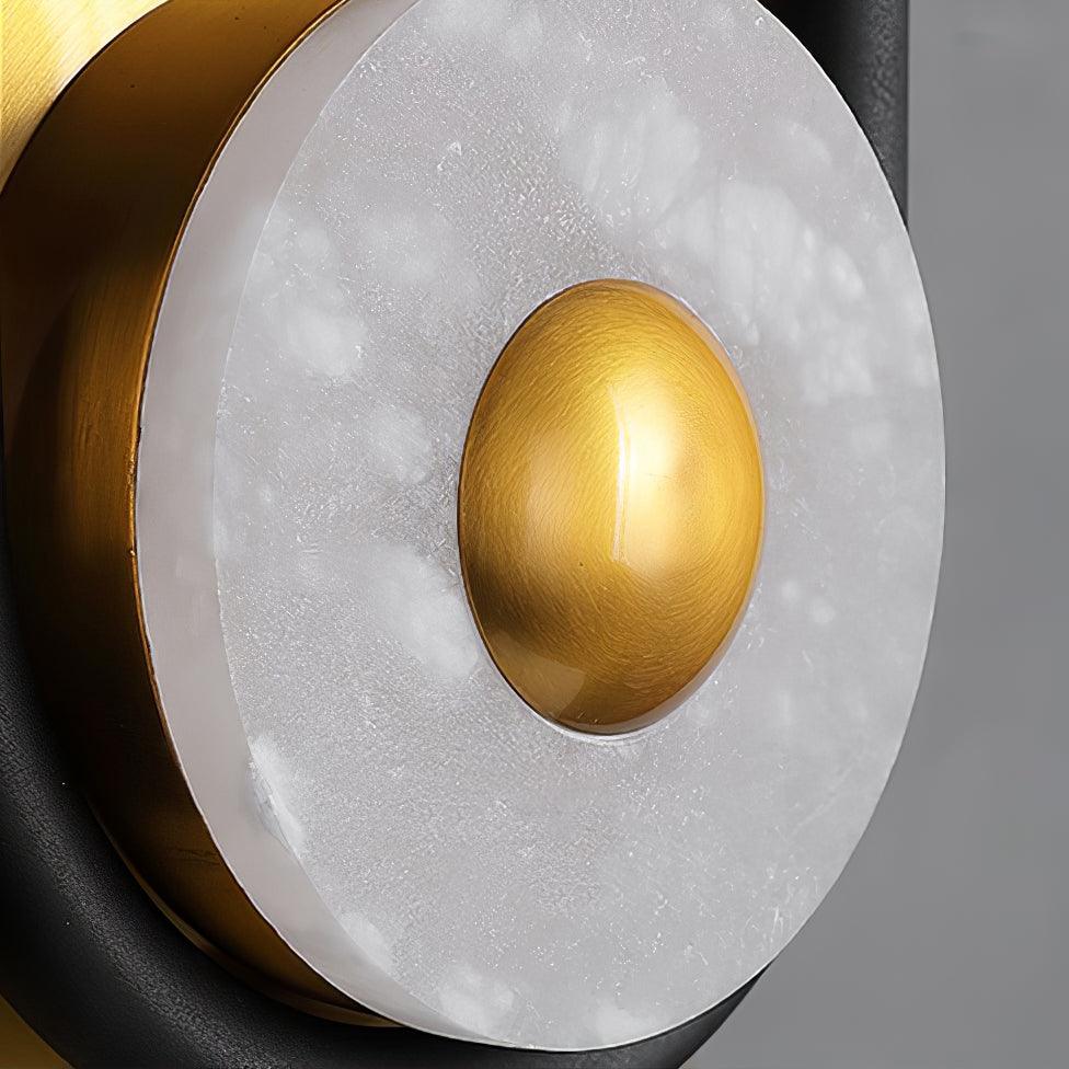 A second close-up of the Clérachic wall sconce's marble ring, shot straight-on to show the stone's grain around the gold dome.