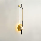 A Clérachic wall sconce is photographed at an angle on an off-white wall, showing the depth of its gold loop in profile.