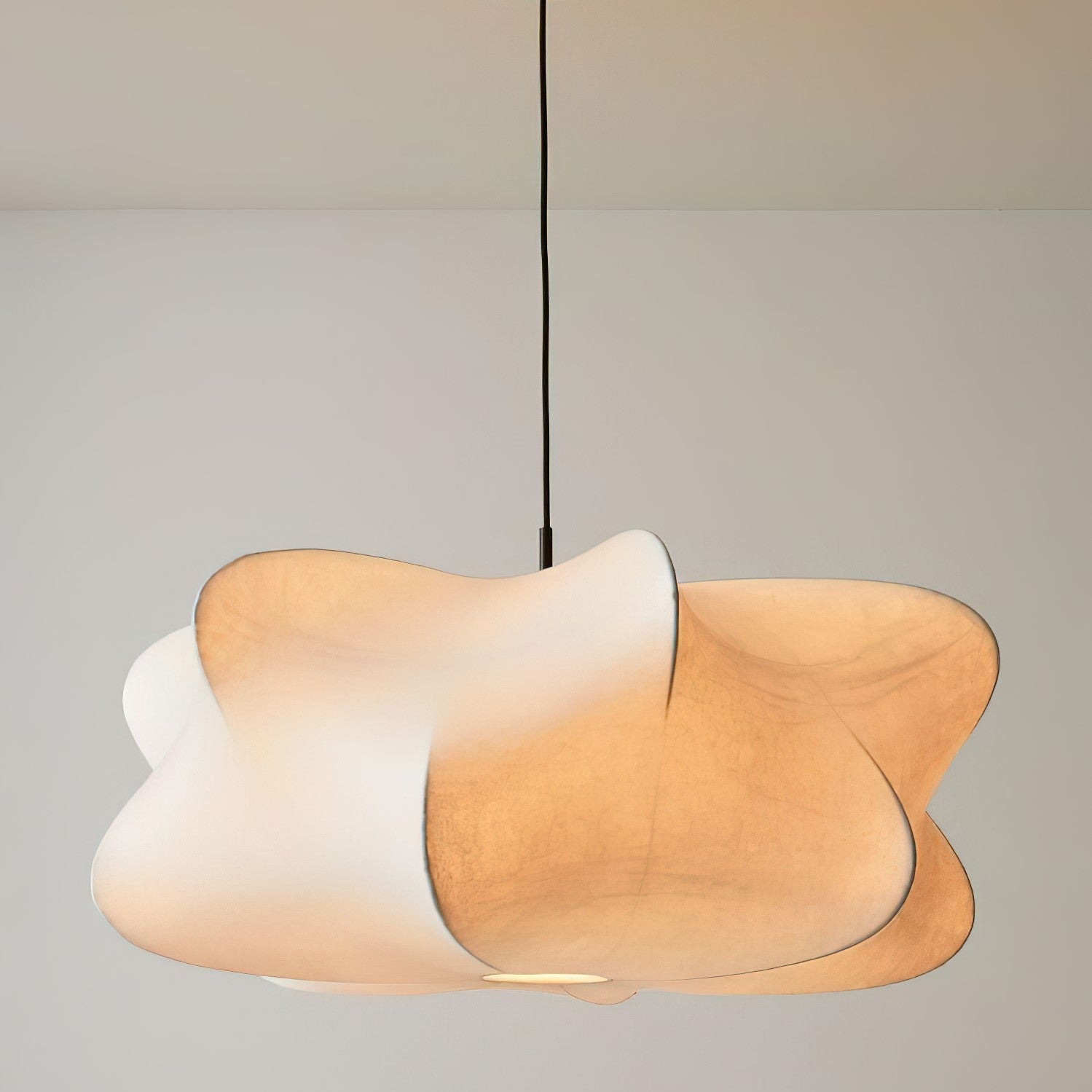 Elysia pendant light with a silk cocoon shade glowing above a dining table