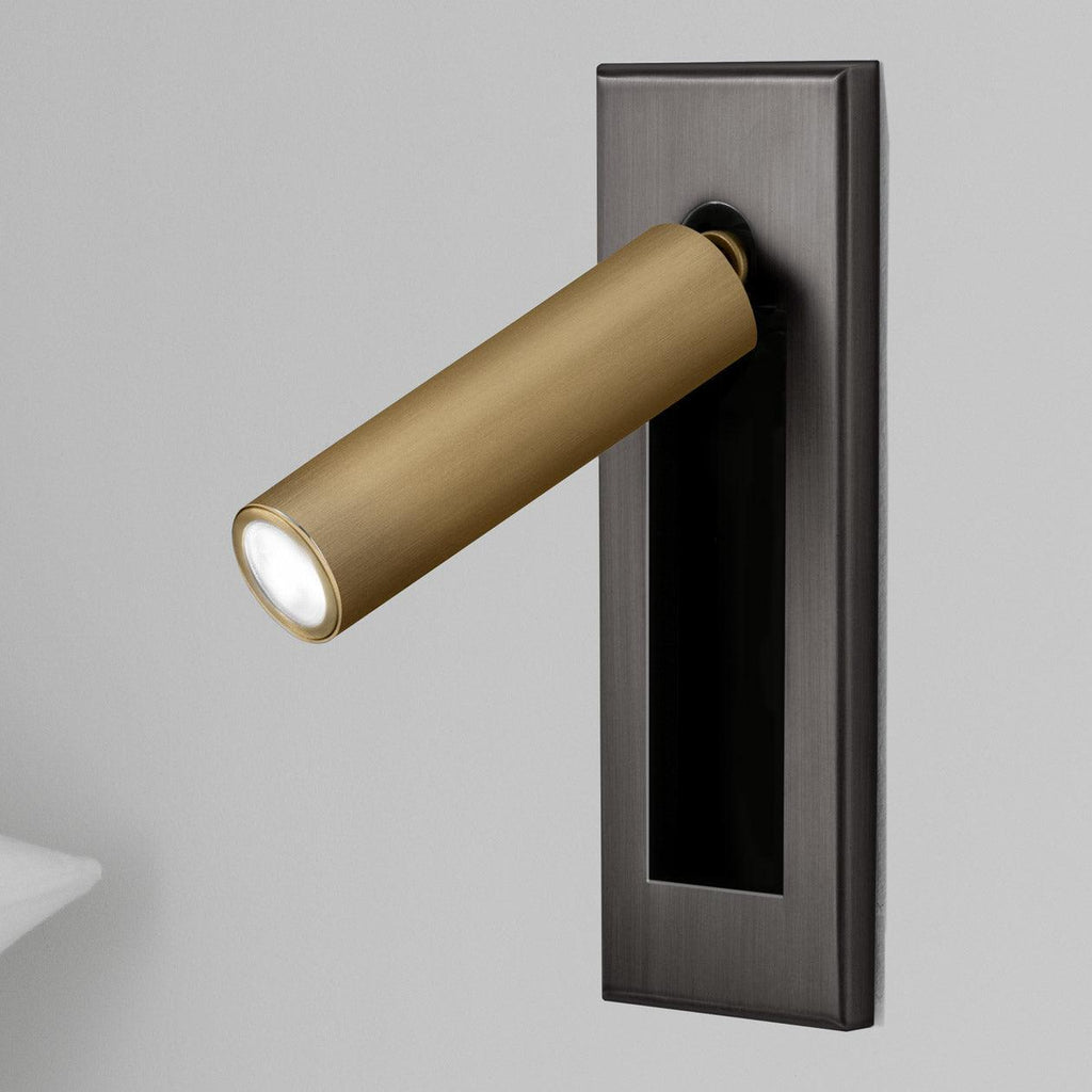 Folding bedside wall sconce extended for focused reading light