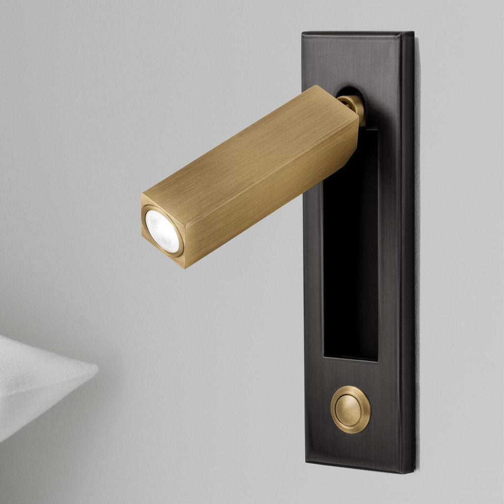 Folding reading wall light angled downward over bedside pages