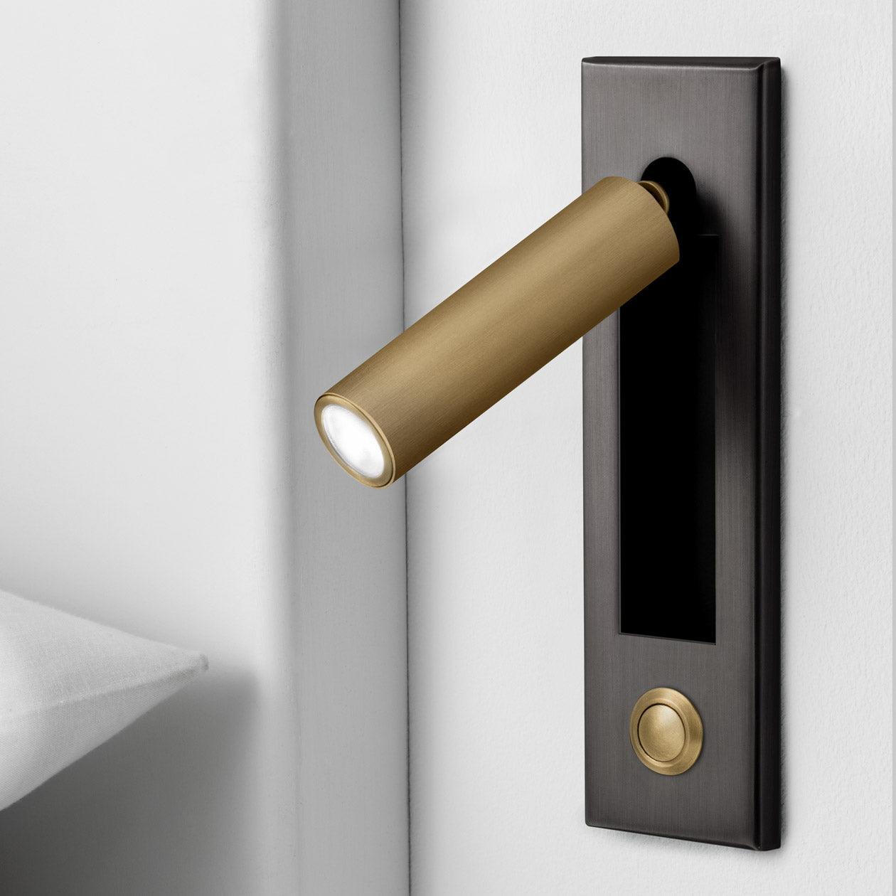 Folding bedside wall sconce extended from a flush wall fitting