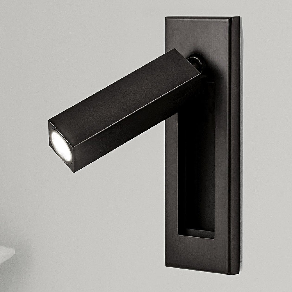 Recessed bedside wall sconce folded out as a reading light above a bed