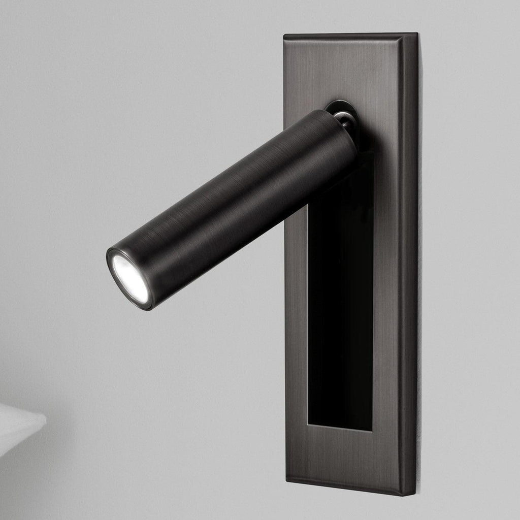 Bedside wall reading light folded flat against a painted wall