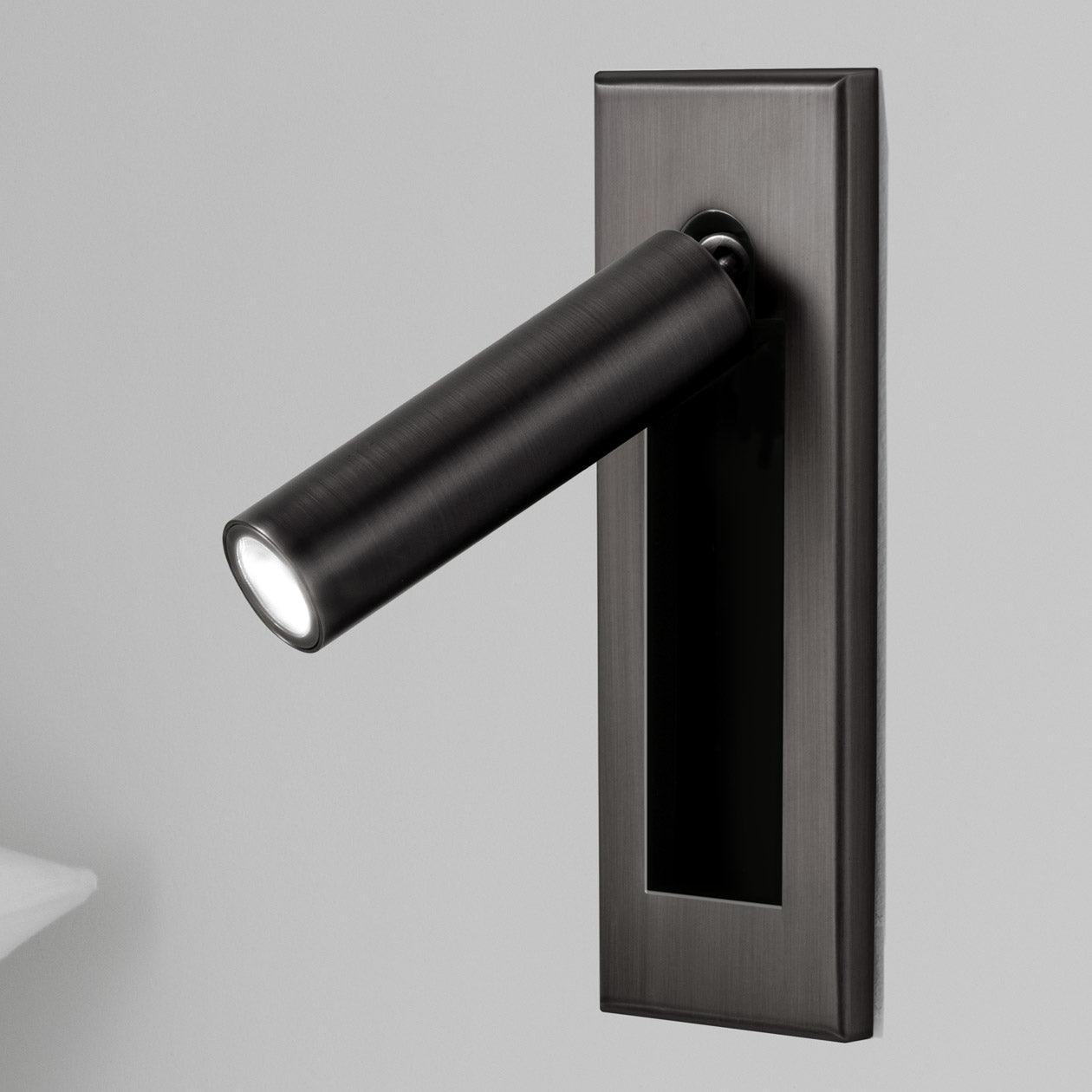 Bedside wall reading light folded flat against a painted wall