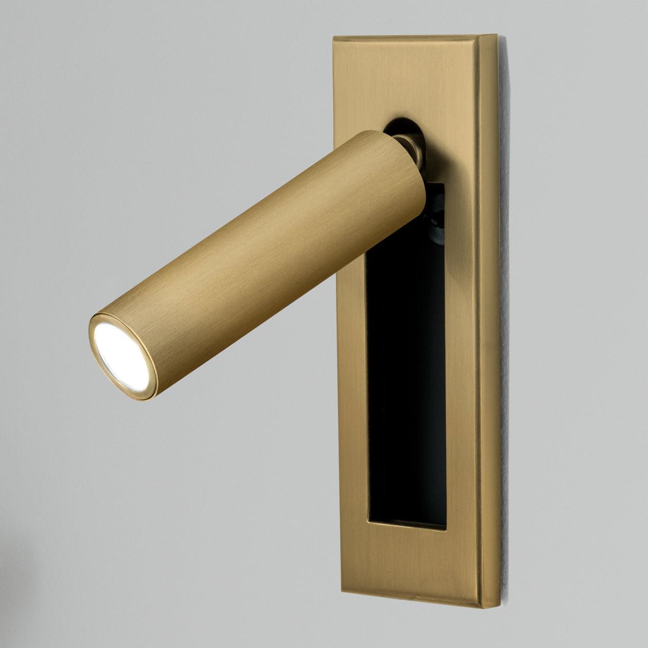 Recessed reading wall light installed beside a calm bedroom headboard