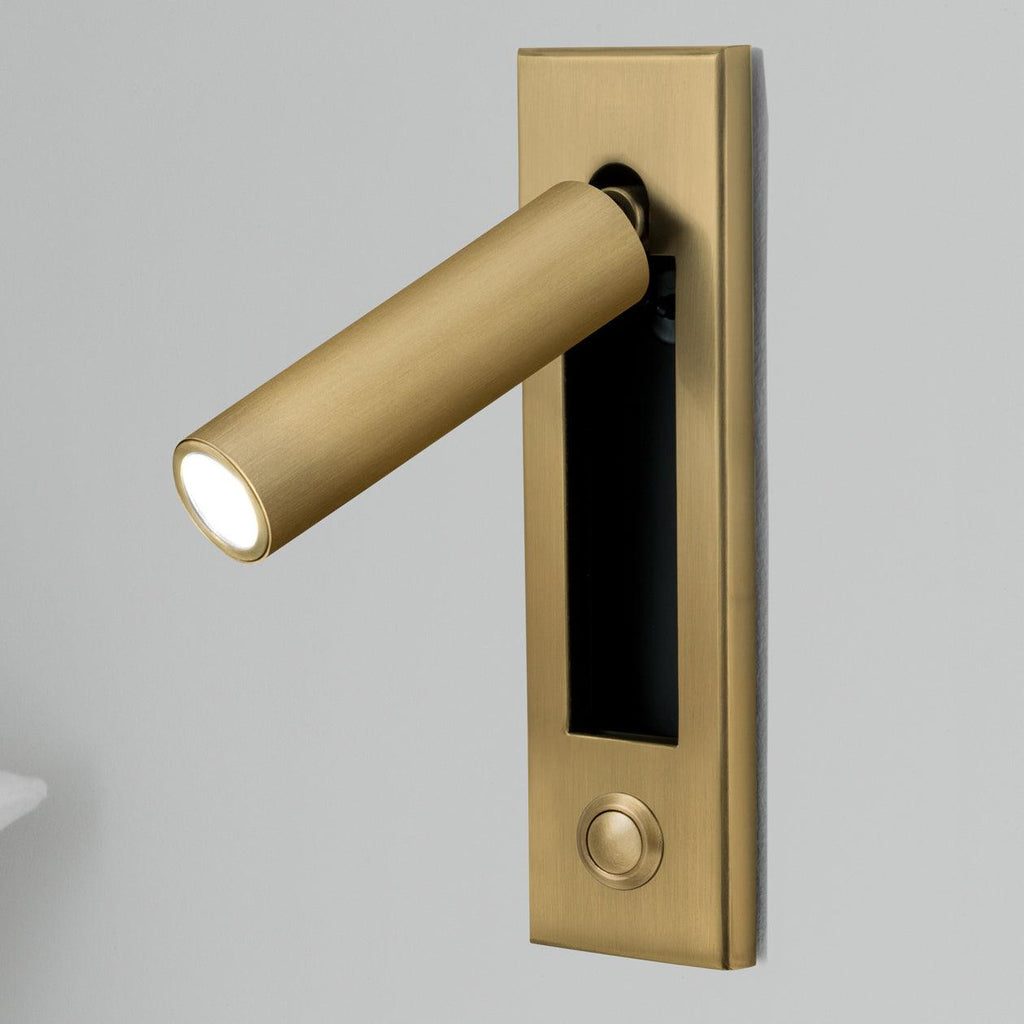Recessed reading wall light beside a bed in a modern bedroom
