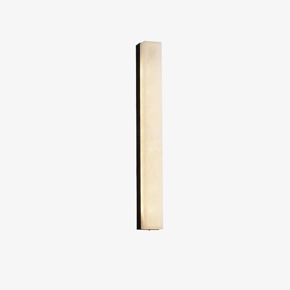 Black-framed Kristy alabaster wall lamp lit on a pale studio background, seen straight on.