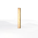 Brass-framed Kristy alabaster wall lamp, lit, angled studio view showing the slim brass edge rail.