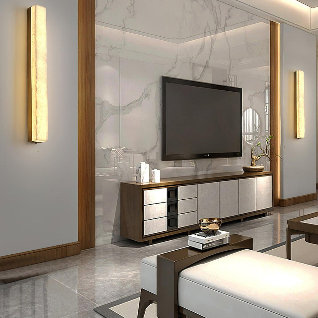 A pair of Kristy wall lamps lit either side of a marble media wall in a living room.