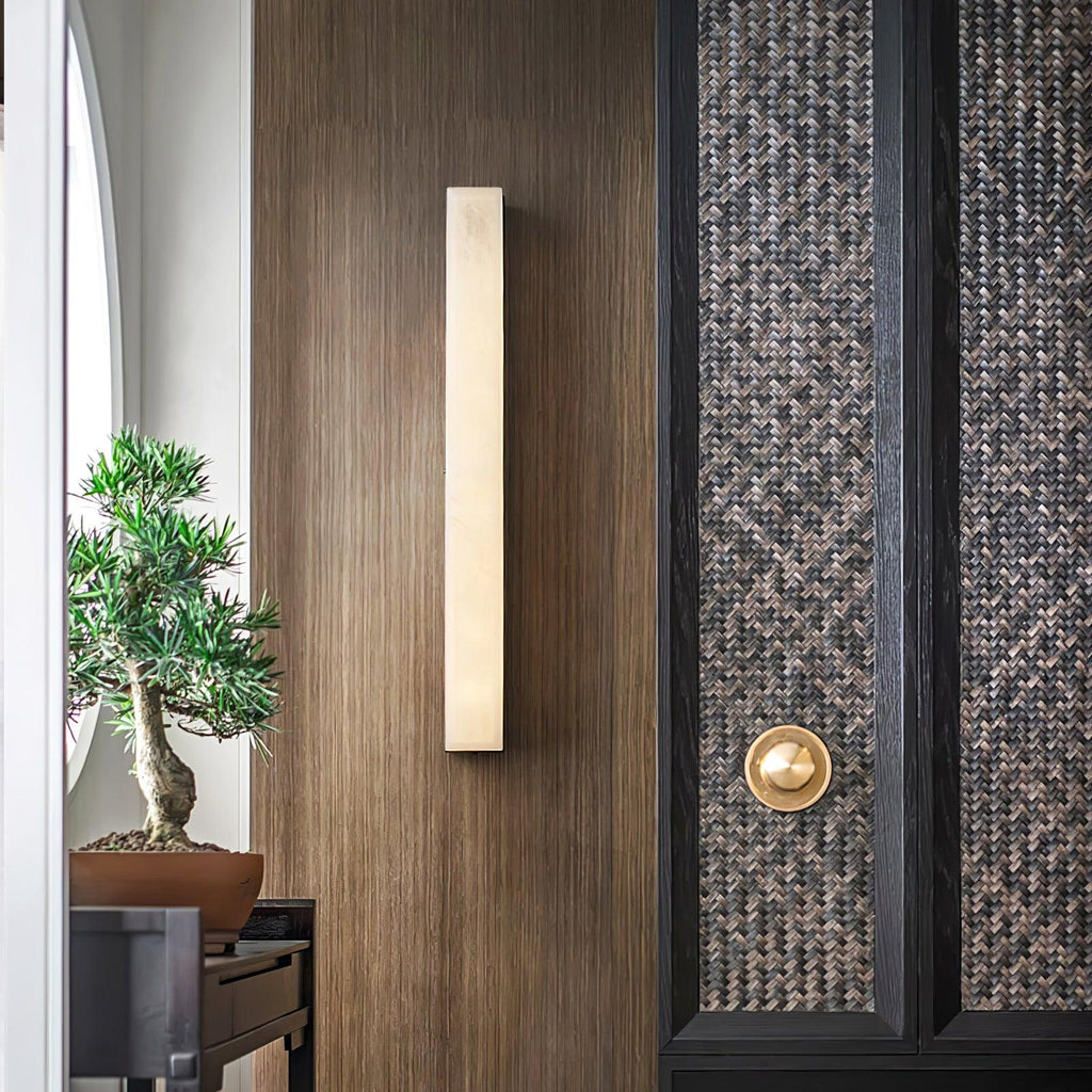 The same walnut entry wall with the Kristy lamp switched off, its pale stone face unlit.