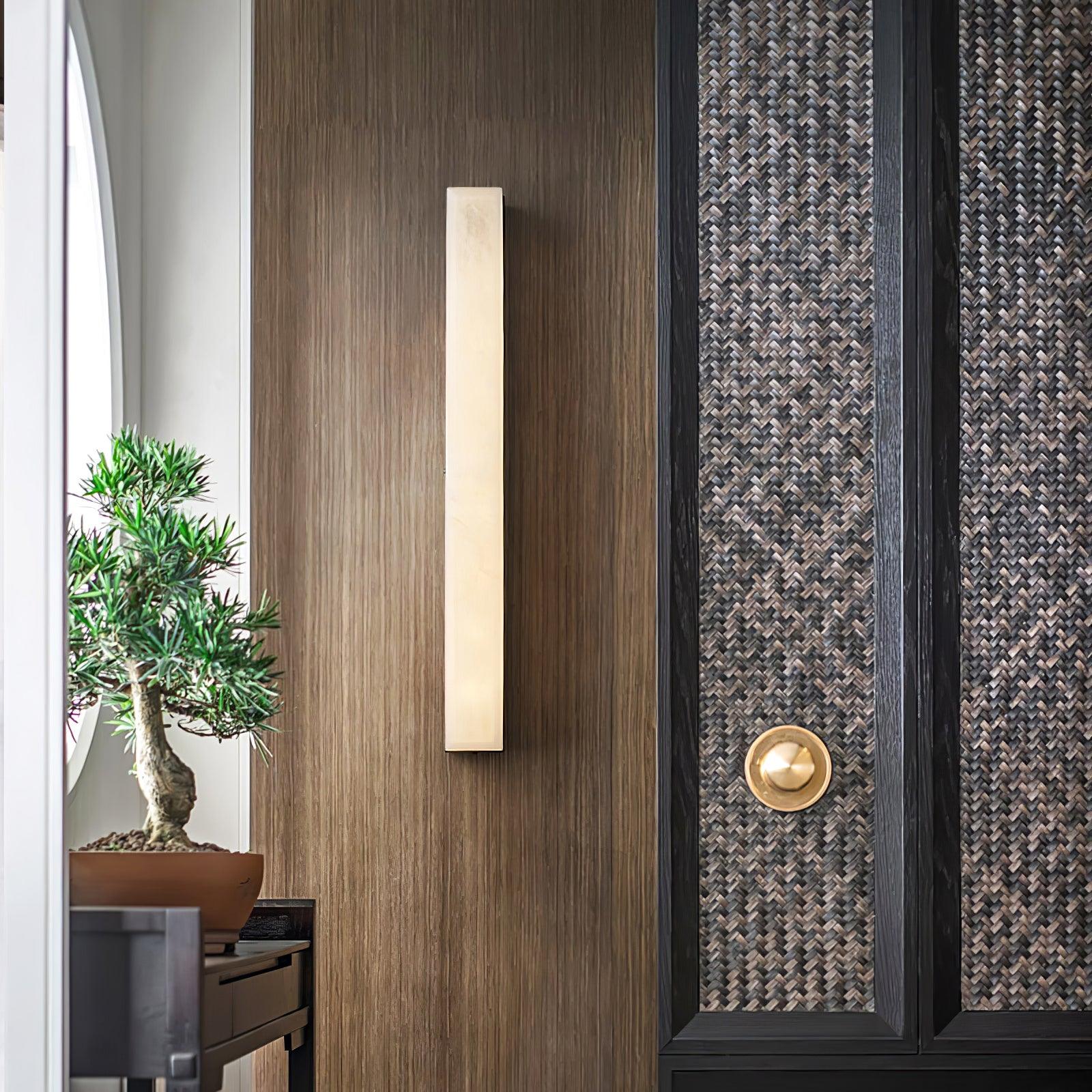 The same walnut entry wall with the Kristy lamp switched off, its pale stone face unlit.