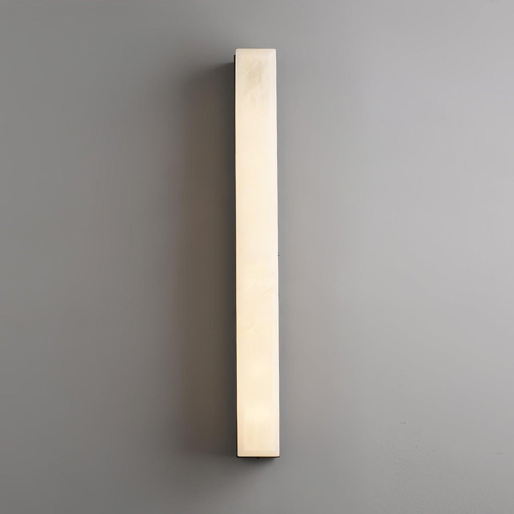 Unlit Kristy alabaster wall lamp photographed straight on against a plain grey wall.
